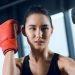 young-female-boxer-exercising-with-trainer-at-gym-CK6XPLK.jpg